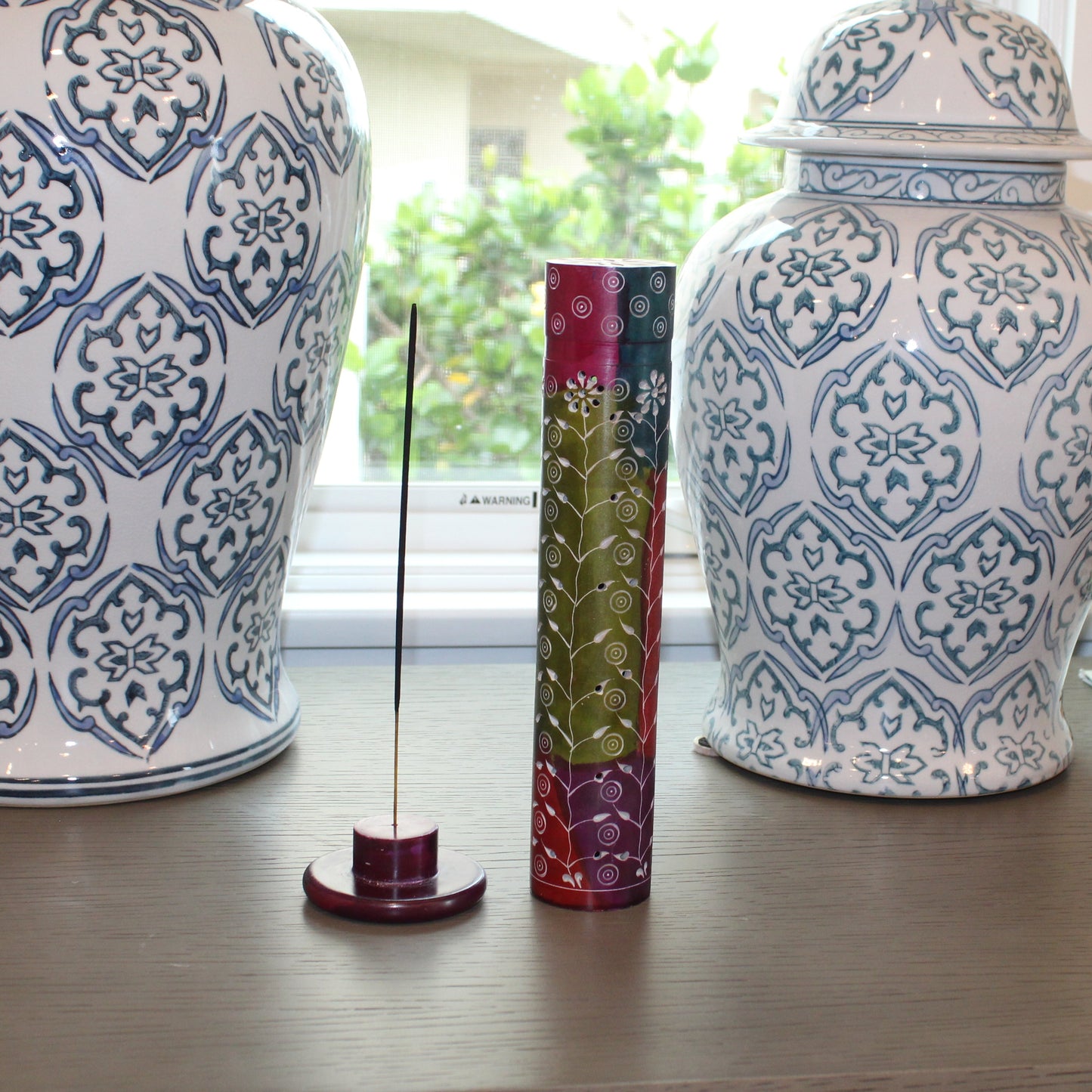 Two decorative vases with intricate patterns on a wooden surface.