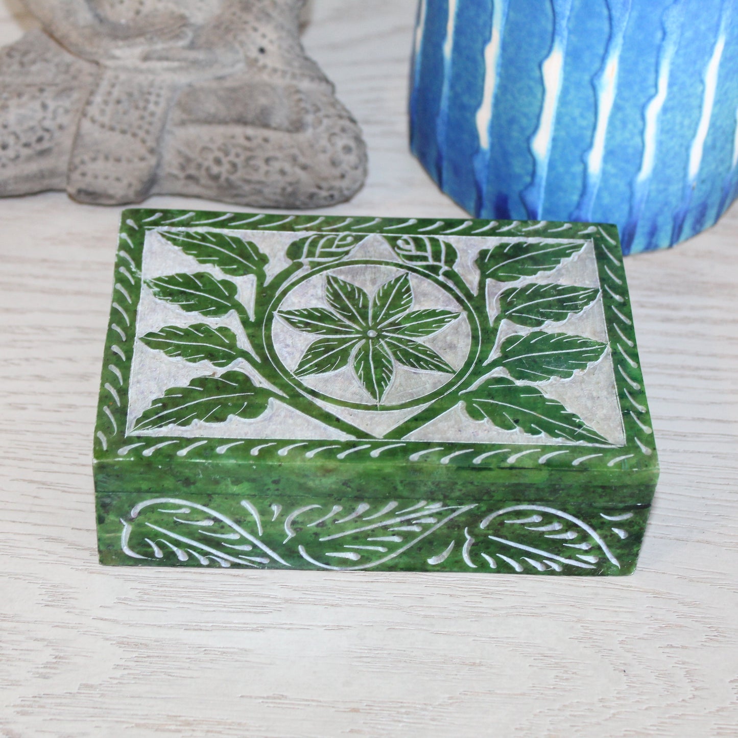 Decorative box with leaf pattern on a textured surface