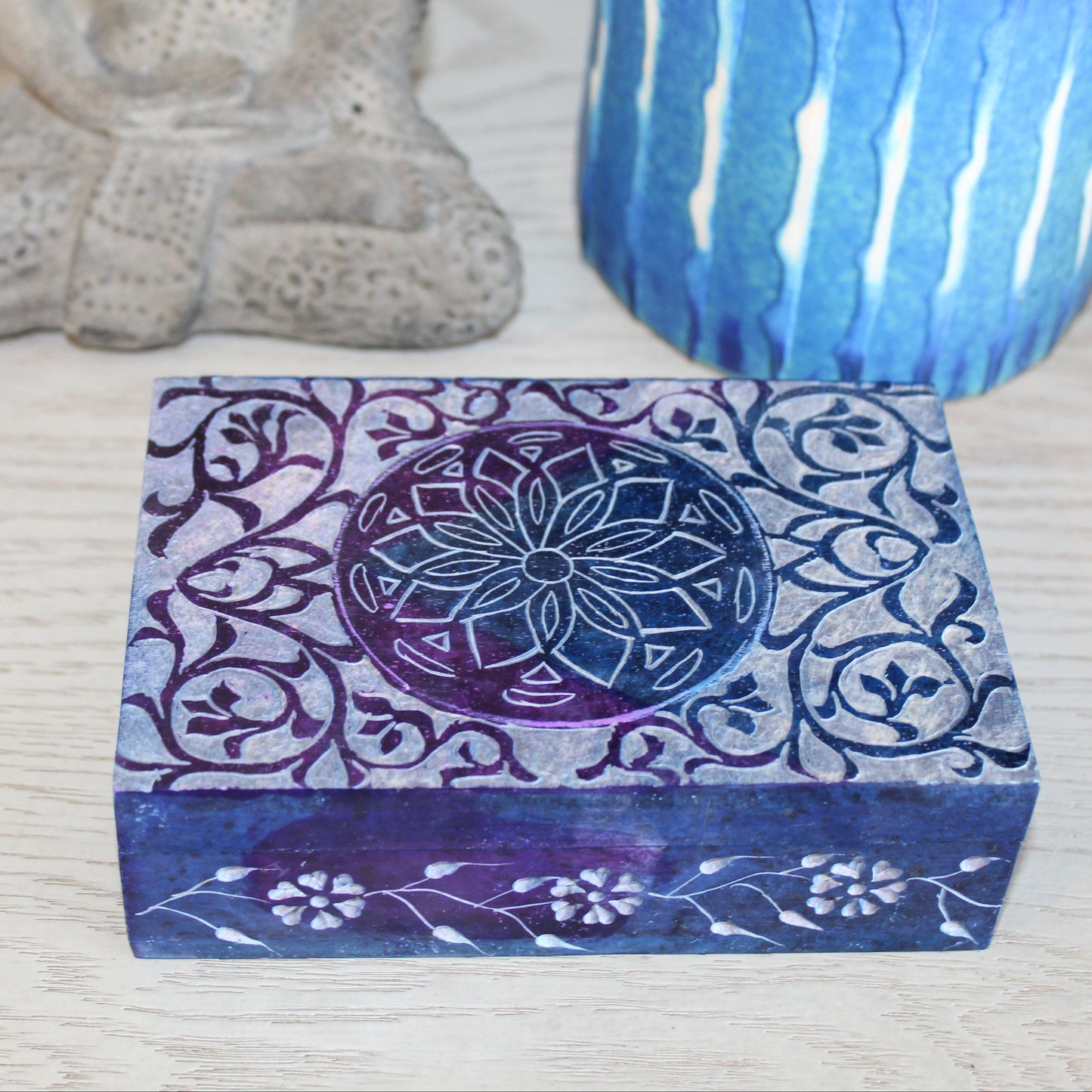 Decorative box with floral patterns on a textured surface