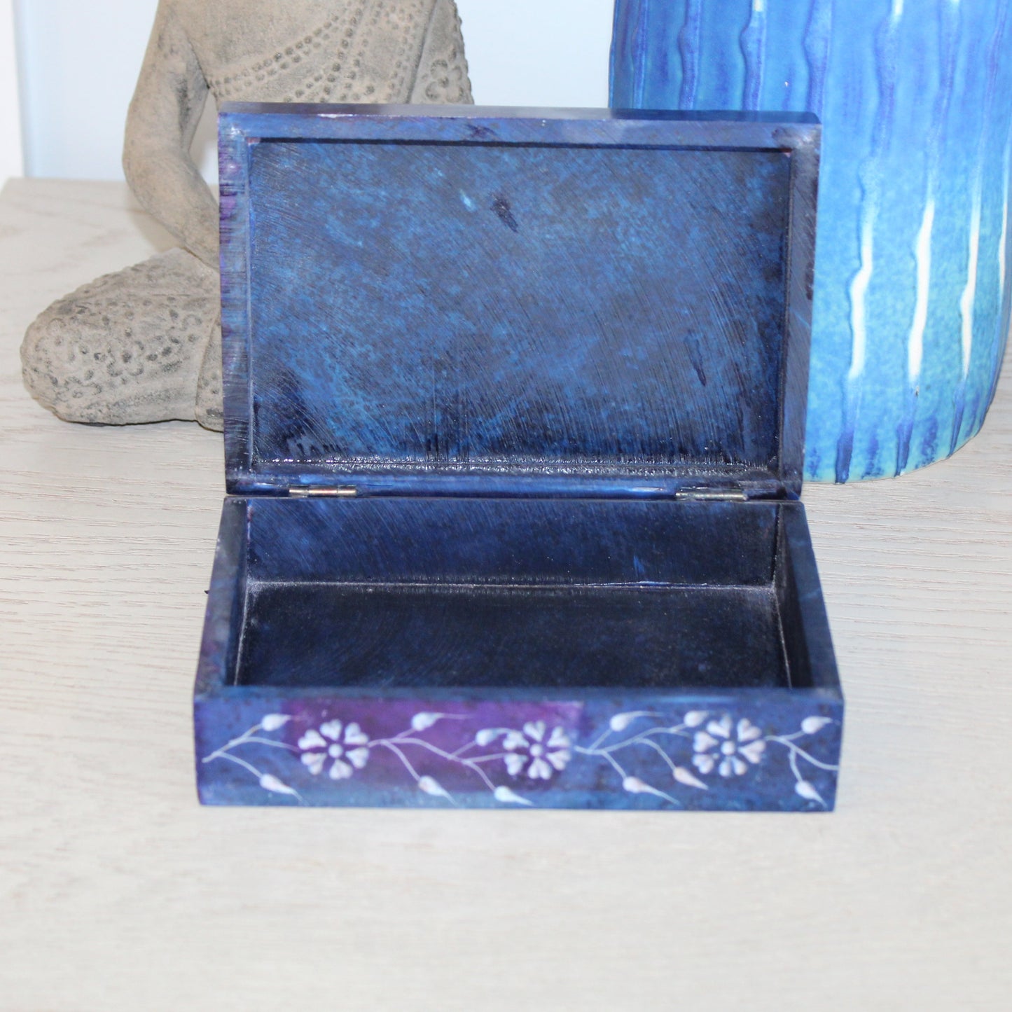 Blue decorative box with floral patterns on a white surface
