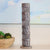 Decorative cylindrical object with patterns on a shelf with a blurred background