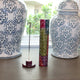 Two decorative vases with intricate patterns on a wooden surface.