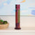 Decorative cylindrical object on a shelf with a colorful abstract painting in the background
