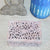 Decorative box with intricate cut-out design on a textured surface with a candle and statue.