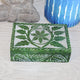 Decorative box with leaf pattern on a textured surface