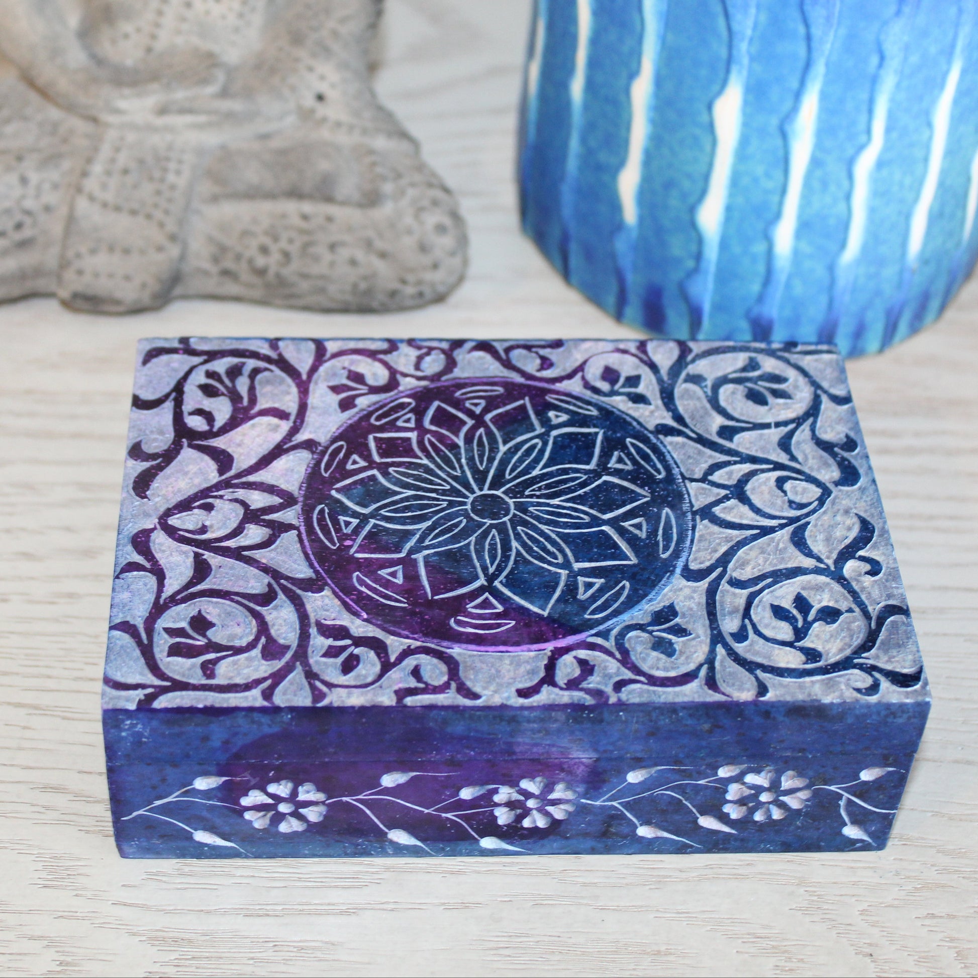 Decorative box with floral patterns on a textured surface