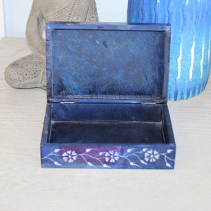 Blue decorative box with floral patterns on a white surface